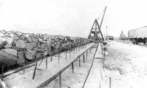 G-5925.1FF2-11 Derrick laying riprap along foundation of Seawall