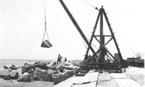 G-5925.1FF3-13 Derrick laying riprap along foundation of Seawall