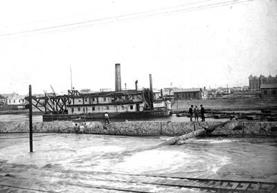 Grade Raising, Photograph of dredge proceeding through canal 