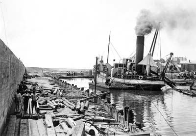 Grade Raising, Photograph of dredge Holm discharging fill while stationed on canal behind Seawall 