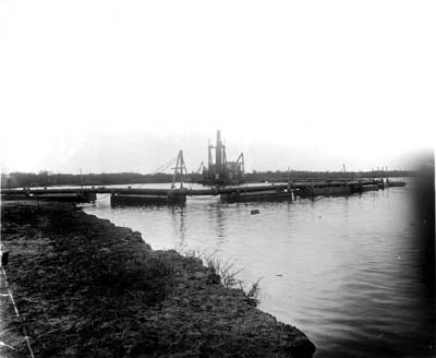 Grade Raising, Photograph of dredge discharging fill while stationed in canal