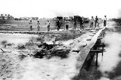 Grade Raising, Photograph of workmen on embankment watching area being filled 