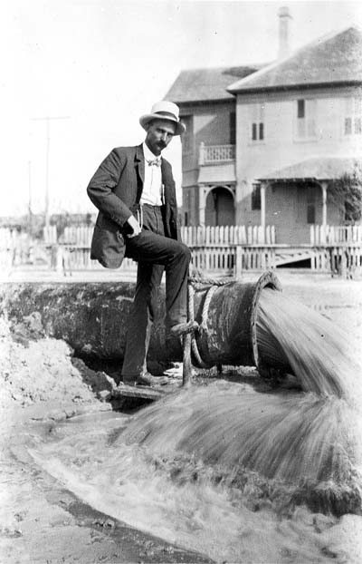 Grade Raising, Photograph of boy walking through fill being pumped into street
