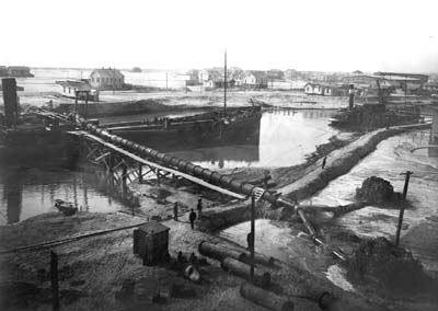 Grade Raising, Photograph of two dredges on canal discharging fill 