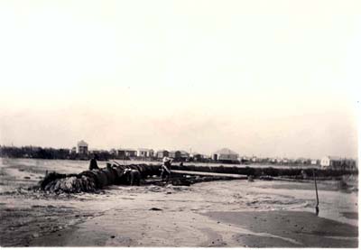 Grade Raising, Photograph of workmen spreading fill as it is pumped into cleared area