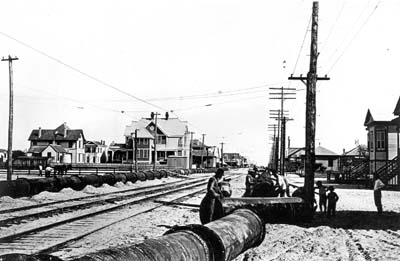 Grade Raising, Photograph of workmen laying pipeline along street