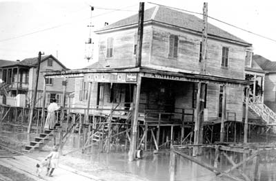 Photograph of woman walking up steps to raised West End Grocery