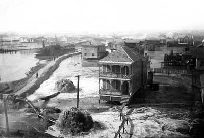 Photograph of pipeline discharging fill around raised houses 