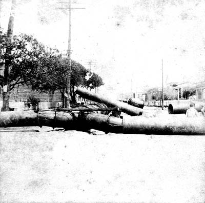 Photograph of pipeline and sections of pipe in residential area 