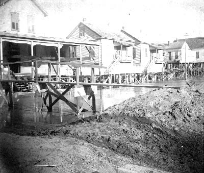 Photograph of view of walkway leading to raised houses 