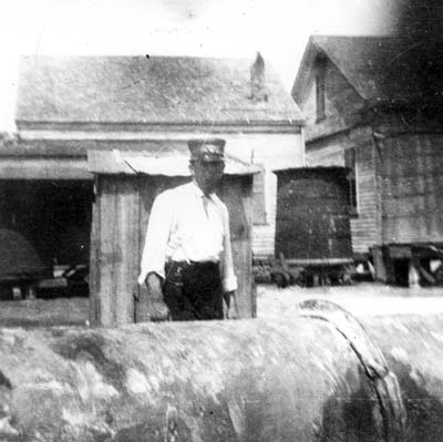 Photograph of man standing behind pipeline in residential area 