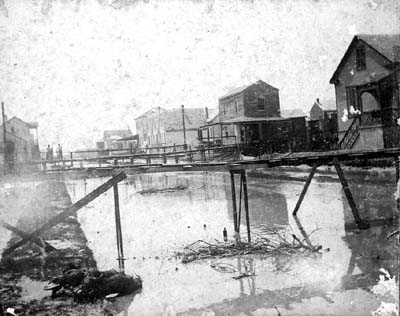 Photograph looking down flooded residential street 