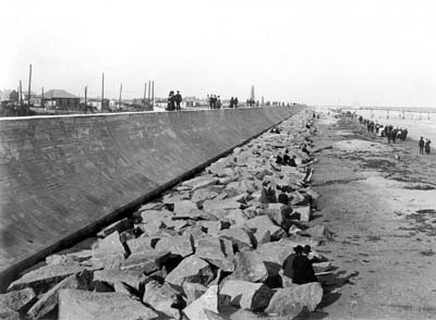 Seawall, Photograph of people seated on riprap and standing on top of Seawall 