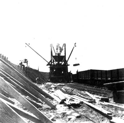 Photograph labeled The 'big mixer' building the wall proper - from behind the wall 