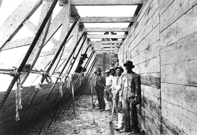 Photograph of workmen standing inside wood caisson 