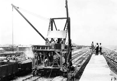 Photograph of concrete mixer traveling next to completed section of Seawall 