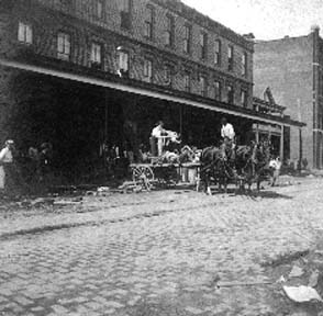 Photograph labeled Church and 23rd, loading dead bodies into wagon