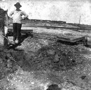 Photograph labeled Down Island. 30 days after the storm burying a body piece by piece.