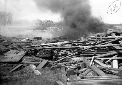 Photograph of body lying face down in debris.