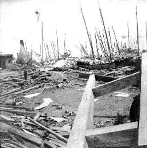 Photograph of wrecked sailings vessels and debrisat wharves