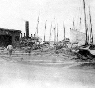 Photograph of steamship and sailing vessels at wharf