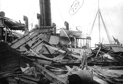 Photograph of man standing on board wrecked steamship.