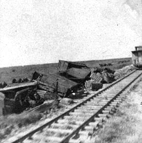 Photograph�of overturned freight cars next to the railroad track