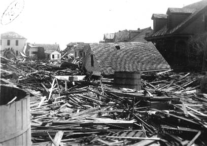 Photograph of roof torn off of house and debris