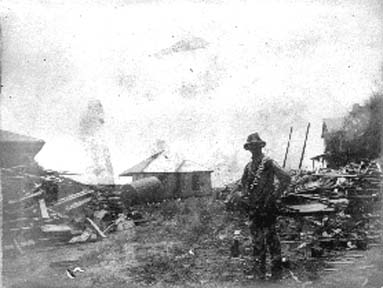 Photograph of workman surrounded by debris