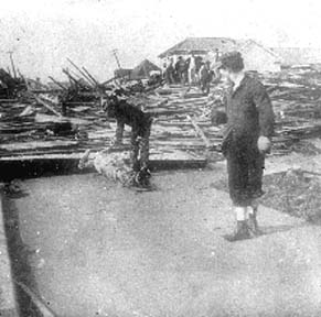 Photograph of man examining body while another man watches