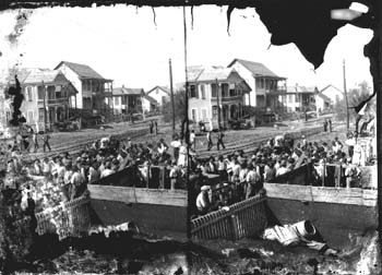 Stereo glass negative of workmen gathered on street