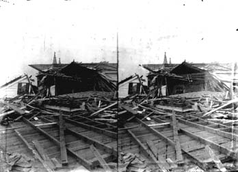 Stereo glass negative of house covered with debris