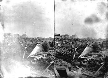 Stereo glass negative of workmen clearing away debris