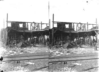 Stereo glass negative of street railway track and gutted building