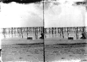 Stereo glass negativ of view of the beach and pilings in water