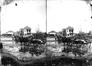 Stereo glass negative of wagons passing through flooded residential area
