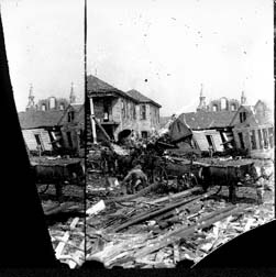 Stereo glass negative of workmen placing debris in wagons in residential area