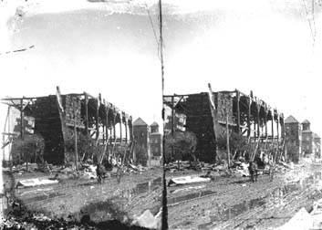 Stereo glass negative of people in horse and buggy going down street amid debris