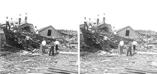 Stereo card of workers standing on wreckage of house
