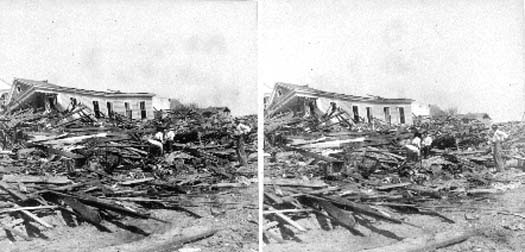 Stereo card of workmen seated and standing amid debris