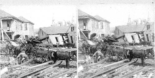 Stereo card of workers placing debris in wagons