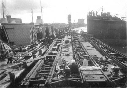 Photograph labeled loading bodies on barge for burial at Sea