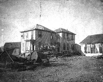 Photograph of people standing on a pile of debris