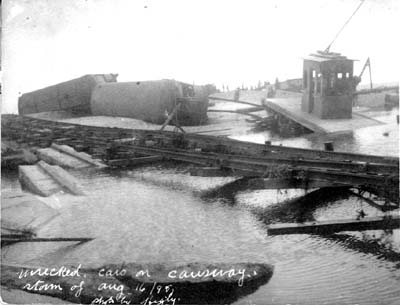 Photograph labeled Wrecked cars on causeway
