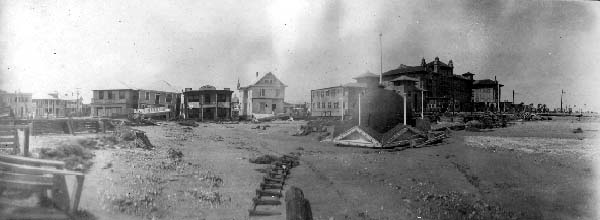 Photograph looking directly at damaged houses lining 23rd(?) Street at Seawall 