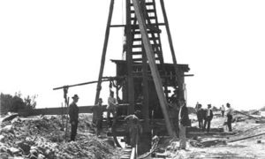 G-5925.1FF1-13 Workmen driving piles along beach