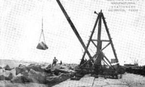 G-5925.1FF3-10 THE GALVESTON SEAWALL.  DERRICK LAYING RIPRAP.  A 1500 LB. ROCK IN MIDAIR.