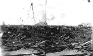 SC#194-42 Distant view of men with horse and buggy amid debris.