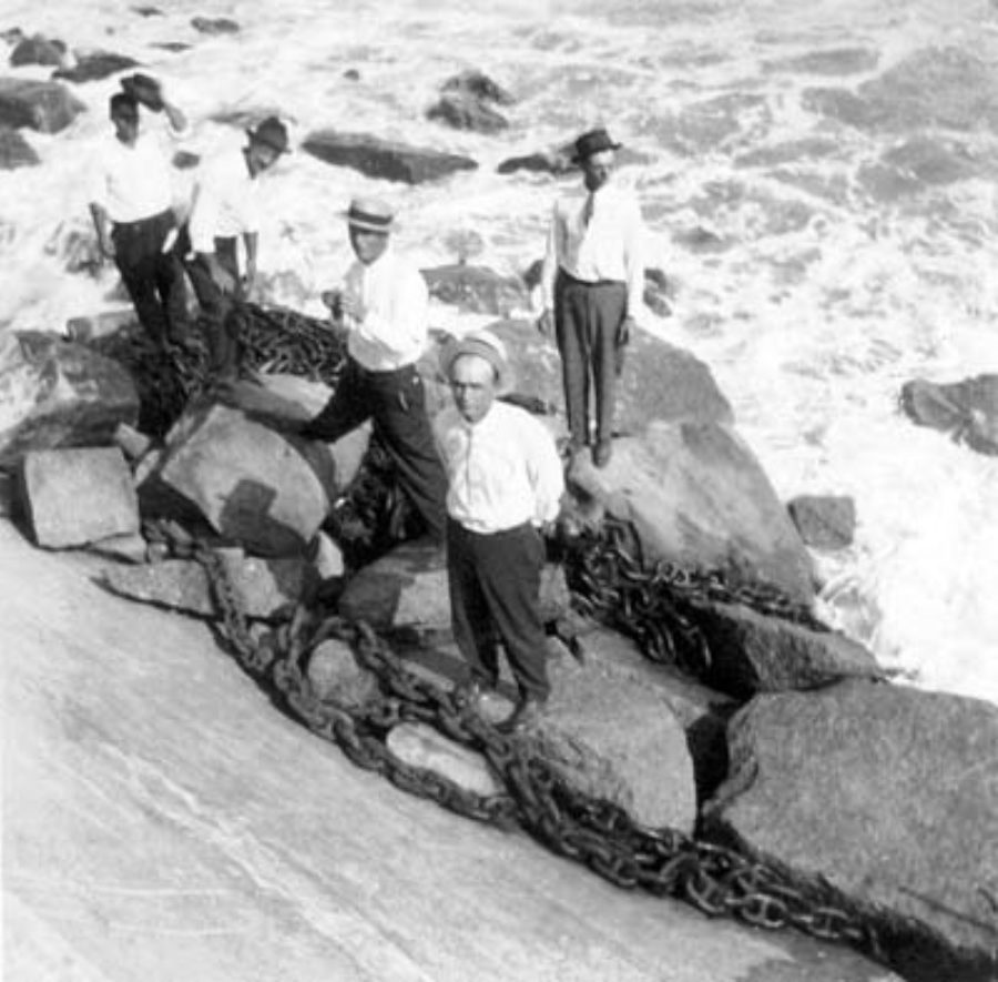 G-17713FF3.1-1 Group of four men standing on riprap at base of causeway