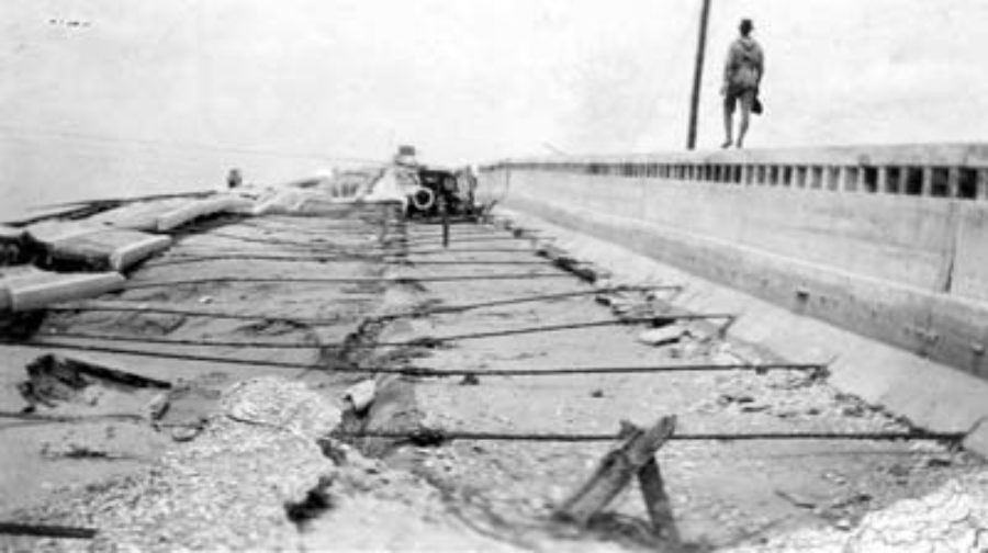 G-17713FF3.1-10 Man walking on top of guardrail of damaged causeway